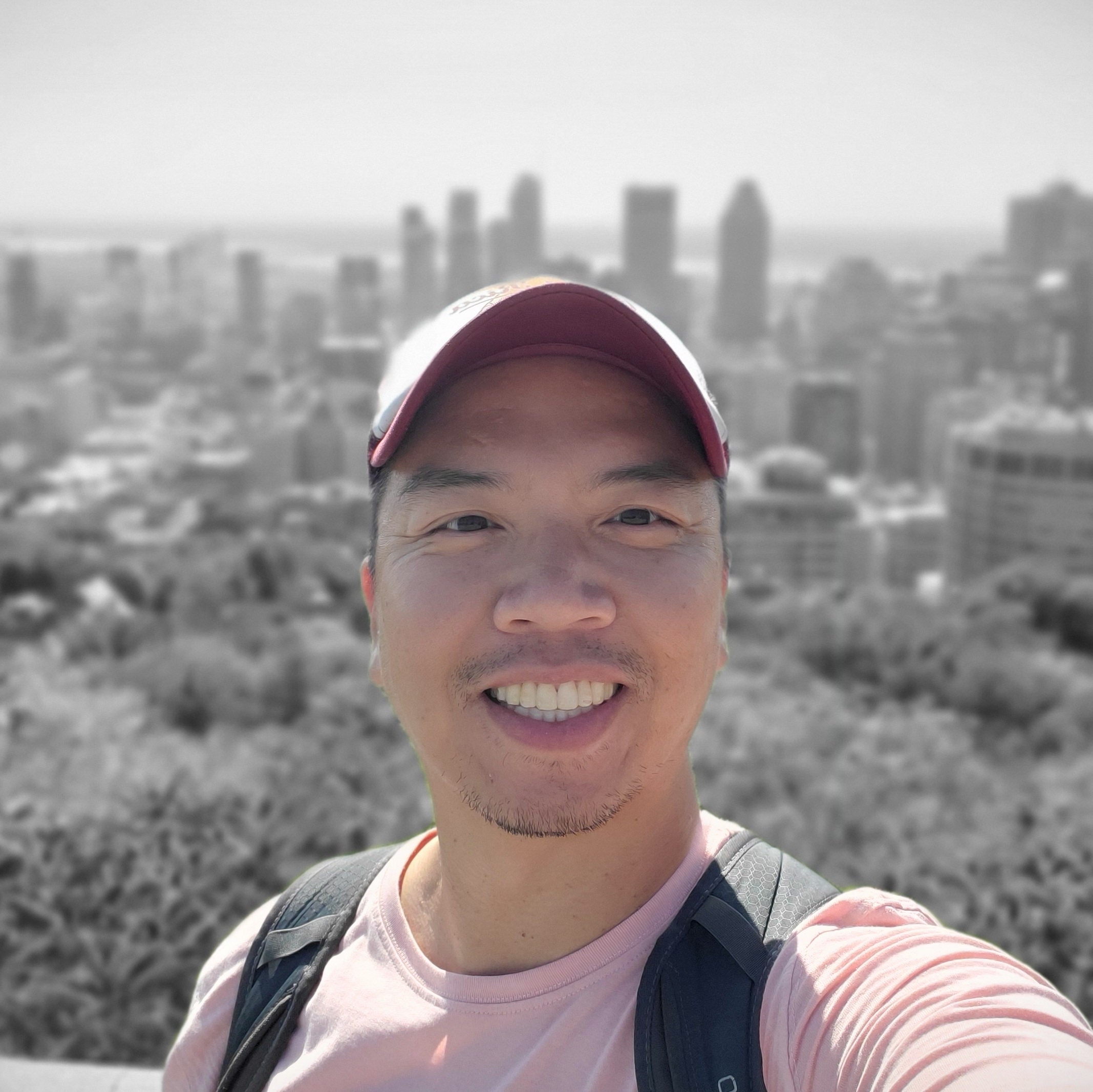 Brian smiling smiling in front of a cityscape.