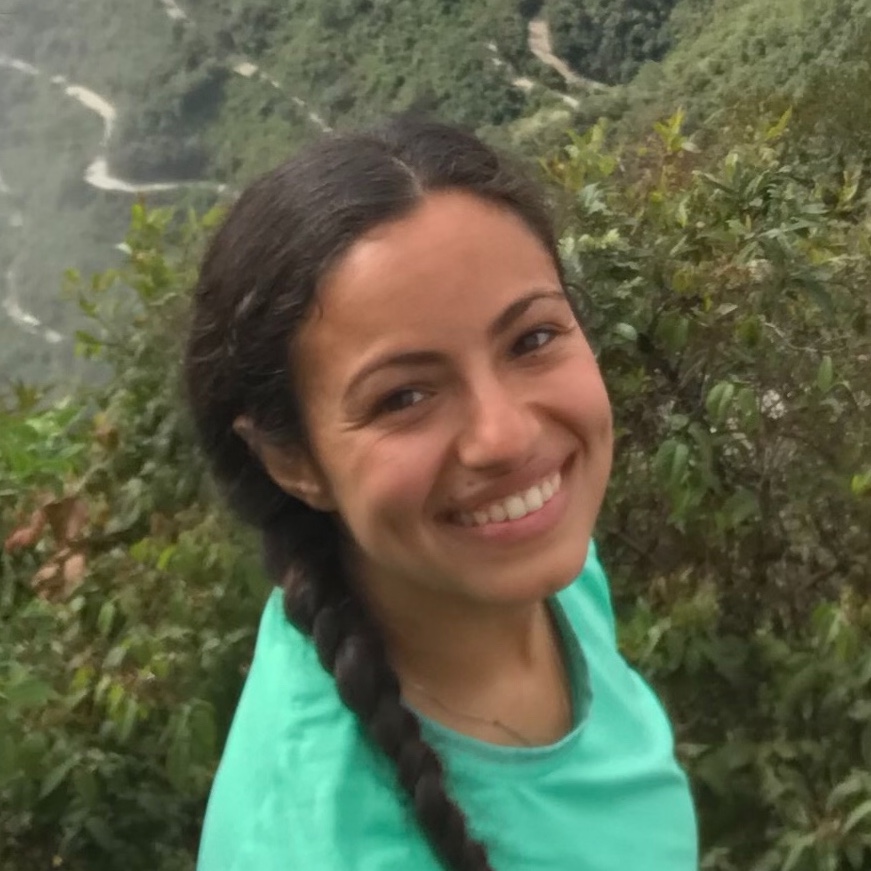 Hana smiling in front of some trees. 