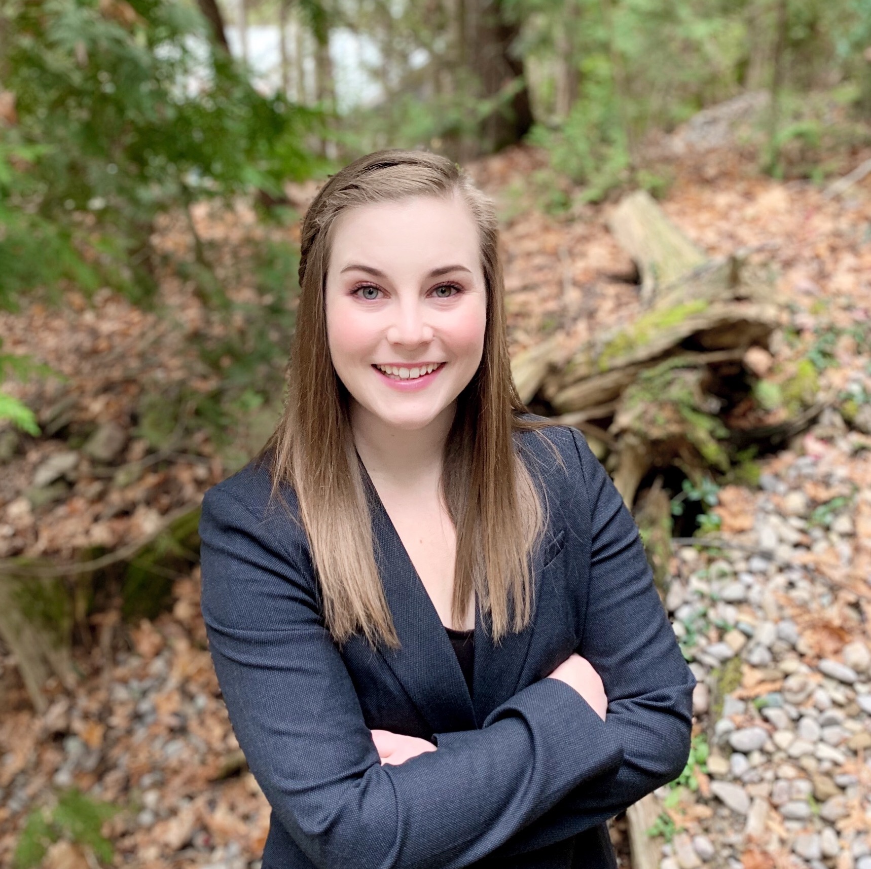 Kerstyn smiling and standing in the woods. 