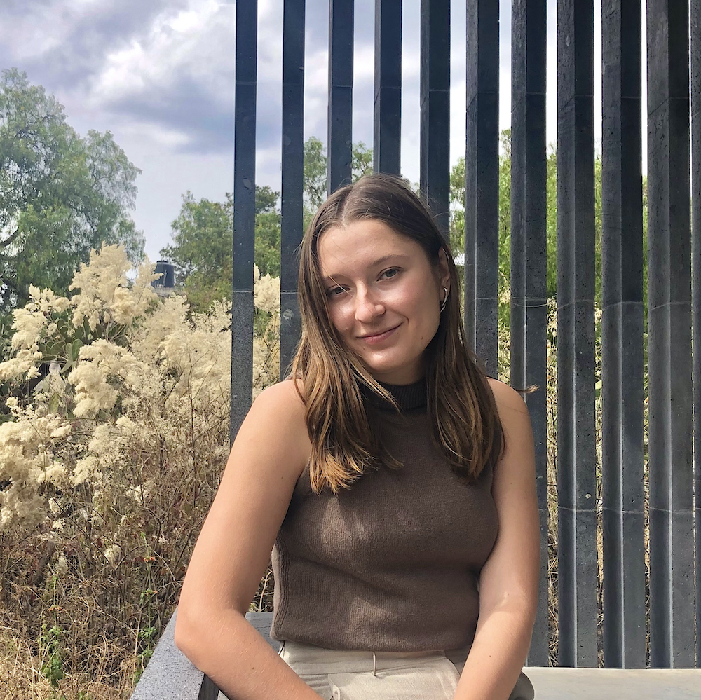 Lidiya smiling and sitting on a porch. 