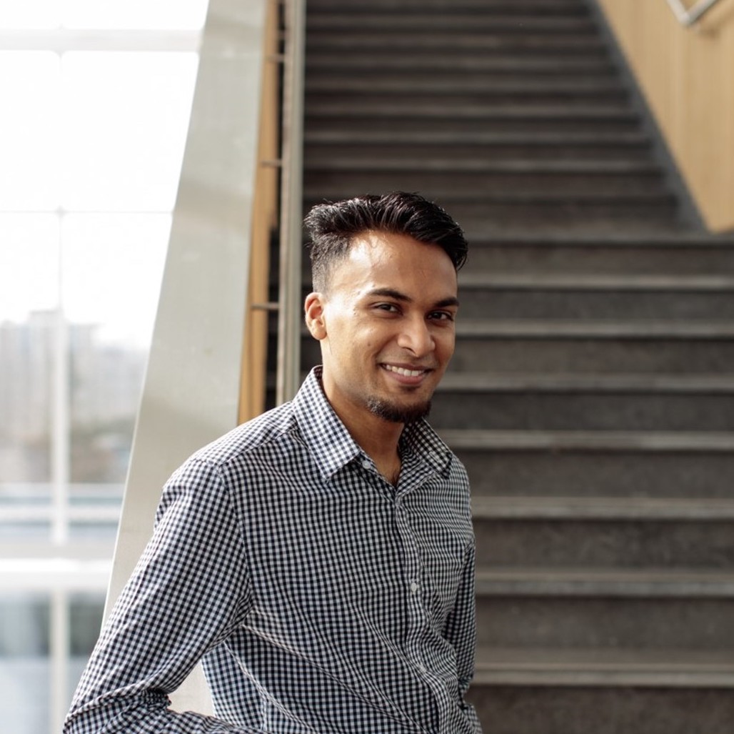 Rameez smiling in front of some stairs. 