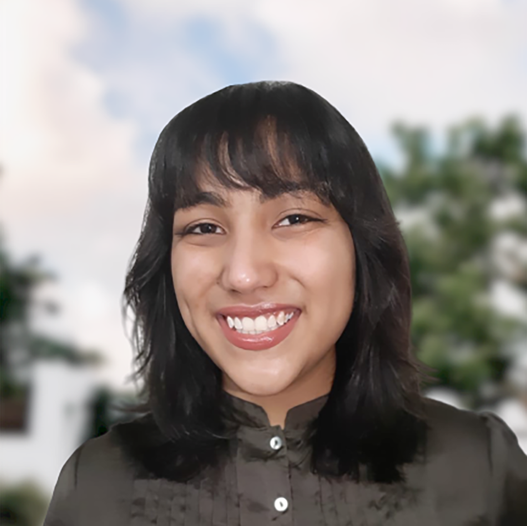 Fahima smiling in front of some blurred trees.