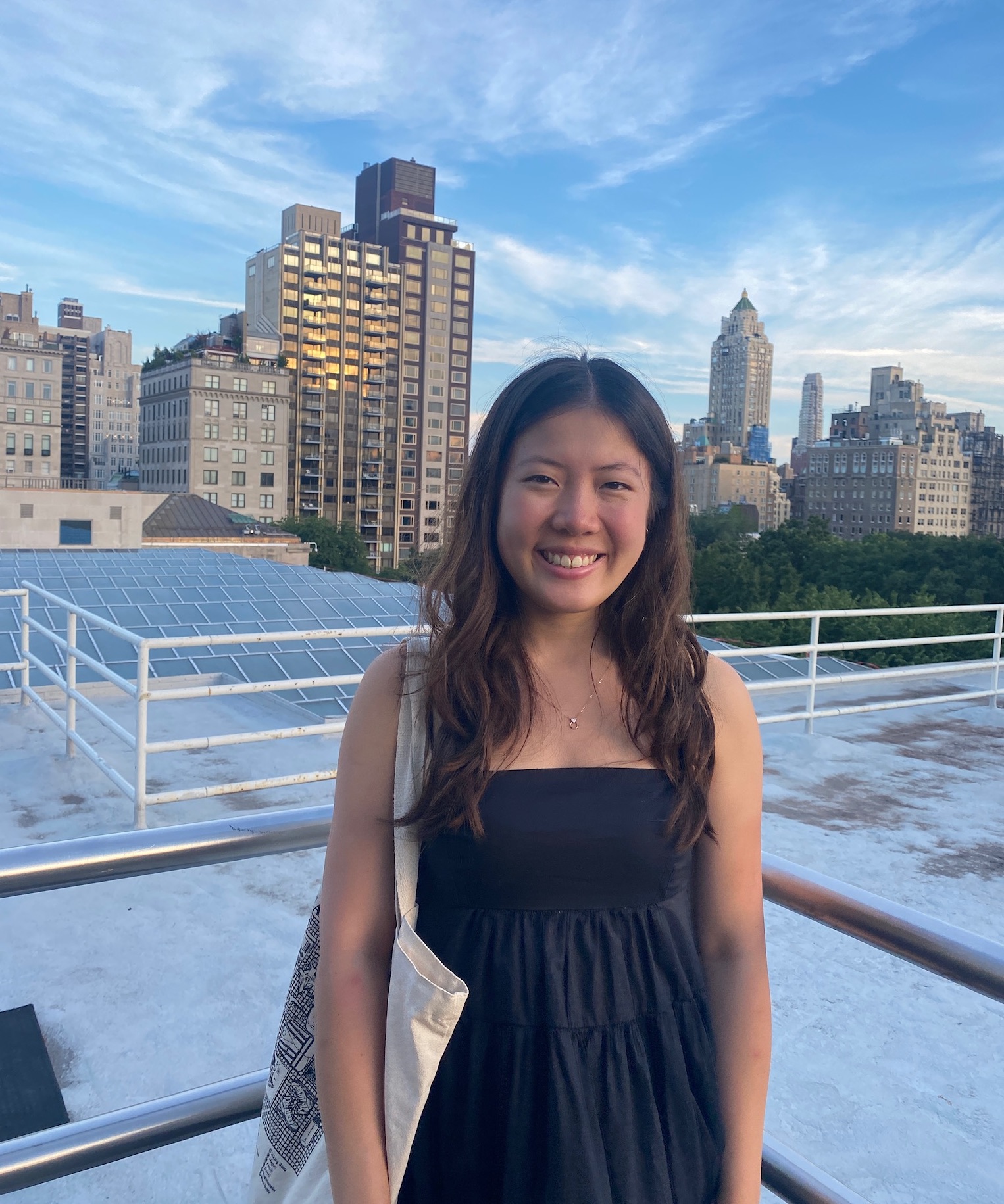 Photograph of Sabrina smiling in front of some buildings.