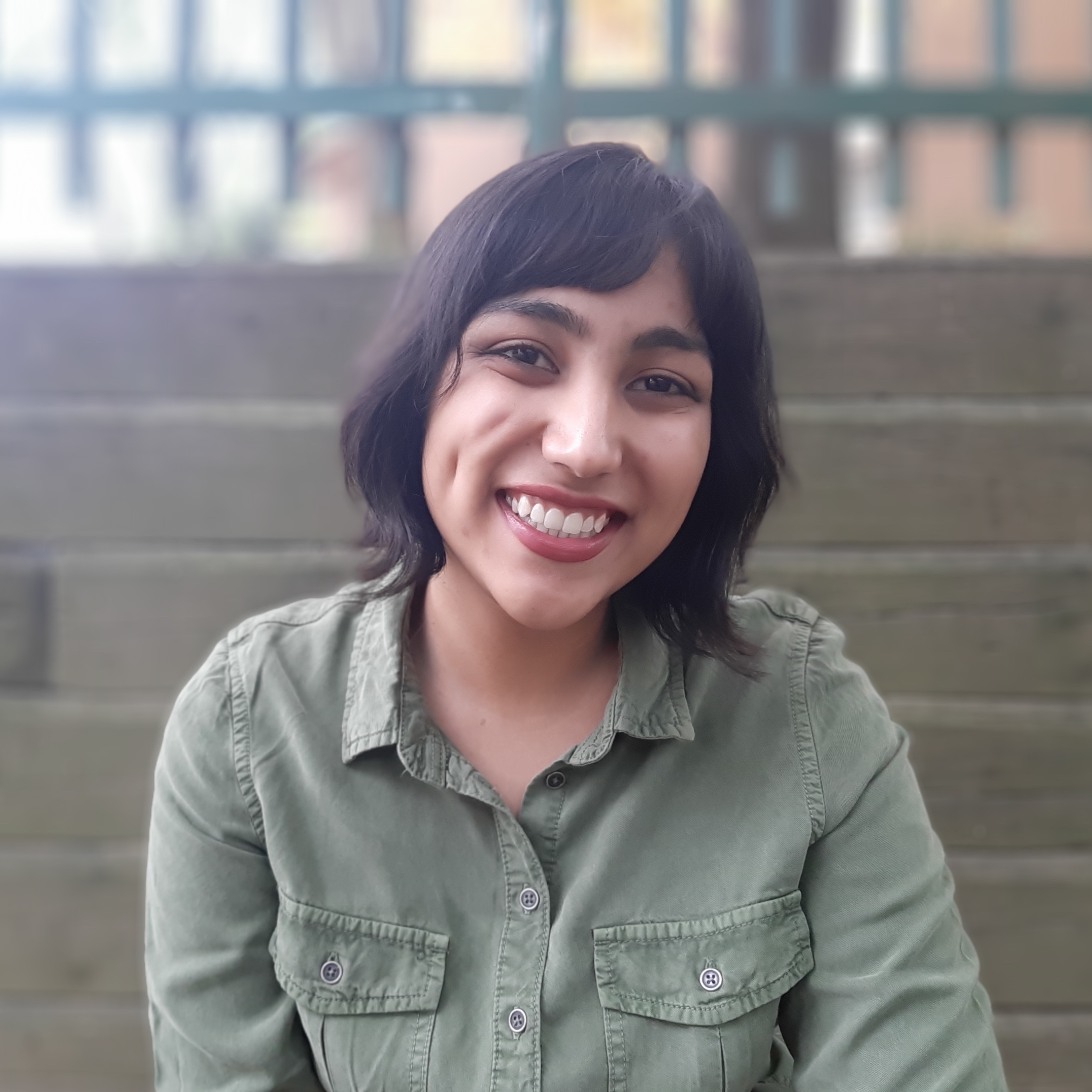 Saieda sitting in front of steps and smiling.