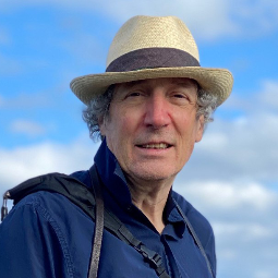 Paul Hess smiling in front of a blue sky.