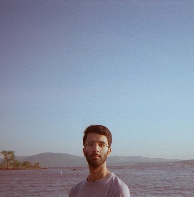 Saheer smiling in front of a lake and mountains. 