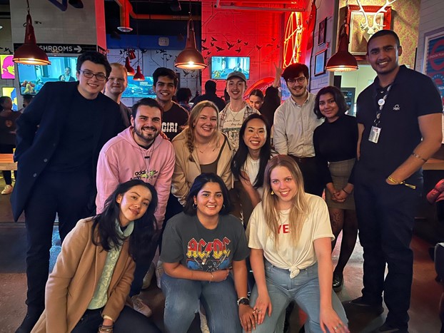 12 undergraduate students posing for photo in pub