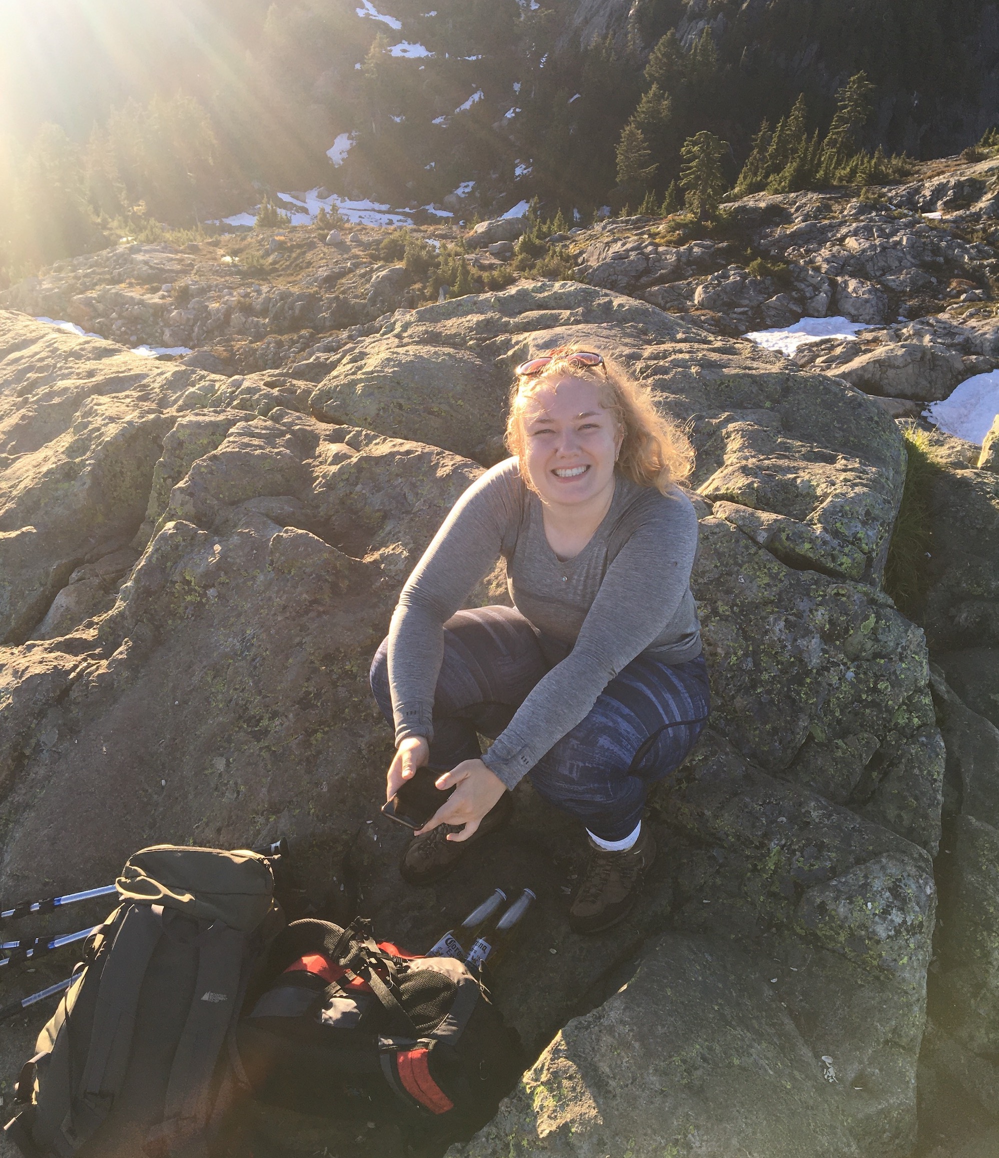 Teagan sitting on a rock and smiling.