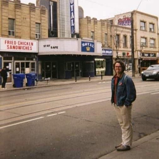 Thomas smiling and standing in front of the Royal theatre.