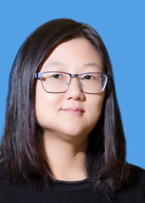 Yuhong He smiling in front of a blue background. 