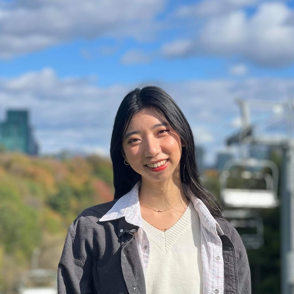 Angel Yang smiling in front of trees. 