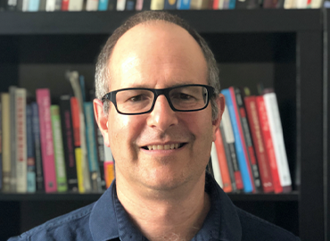 Professor Mark Hunter with books behind him